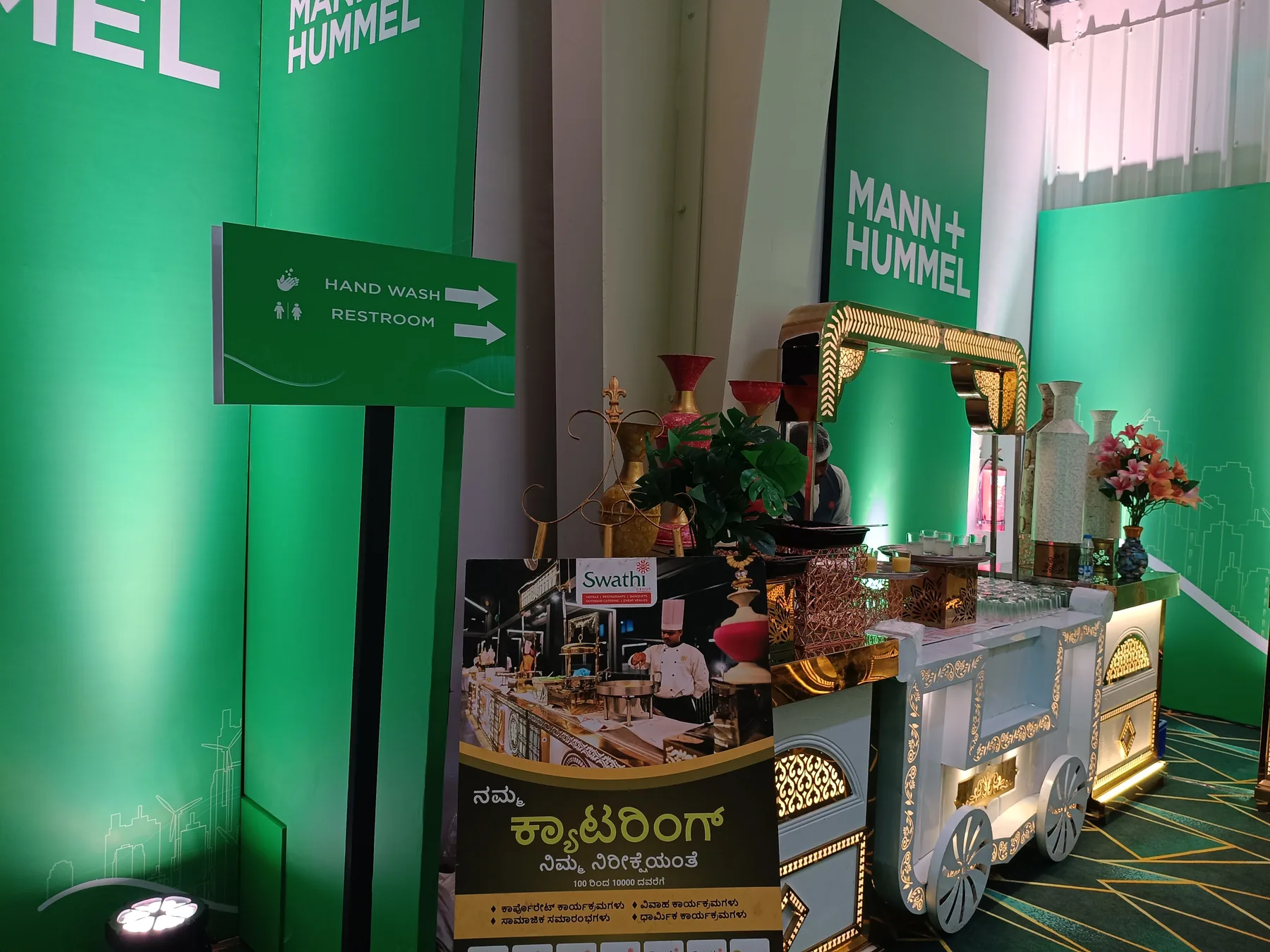 Refreshment cart beside green event graphics