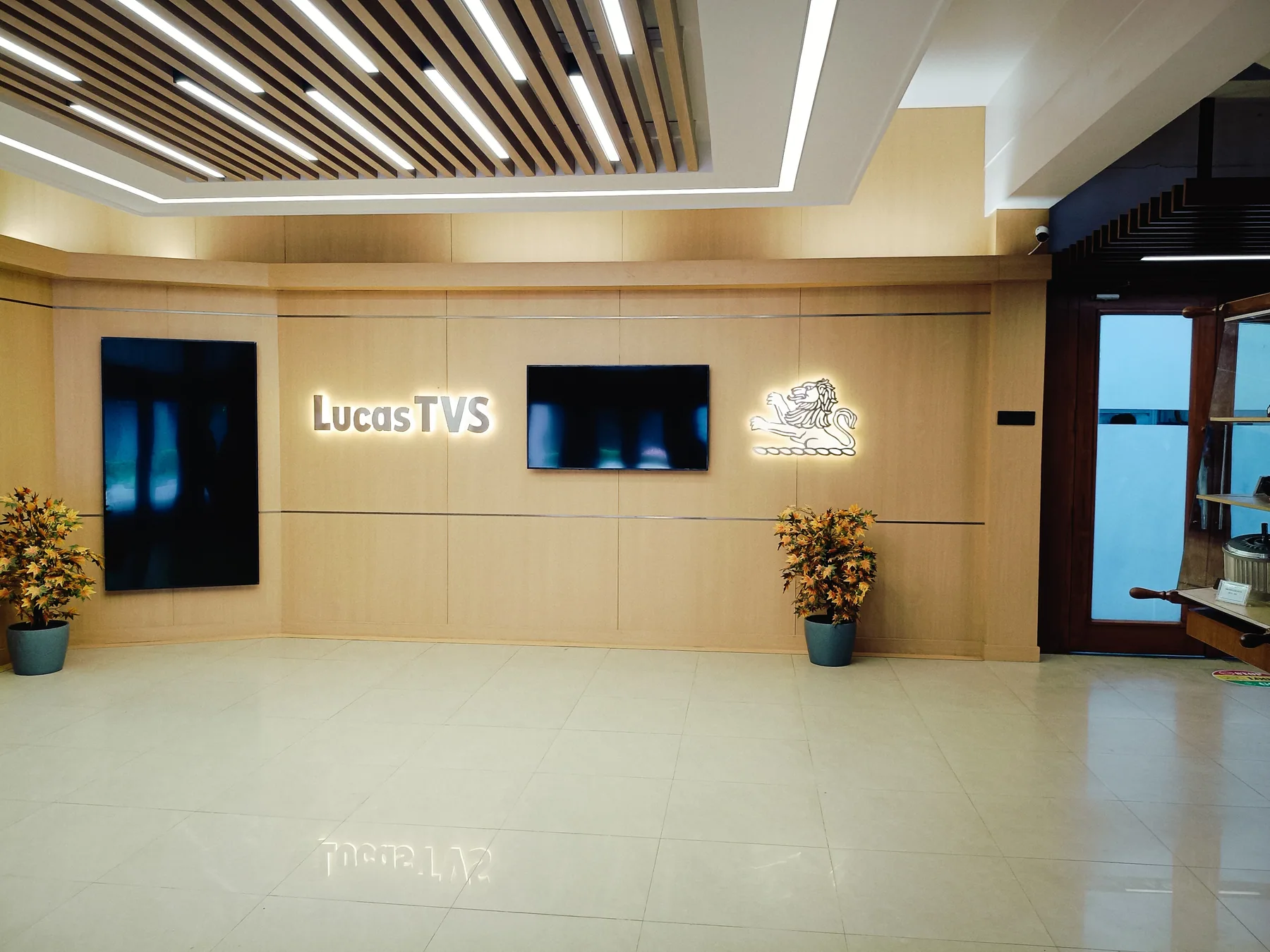 Reception lobby with illuminated branding and linear ceiling lights
