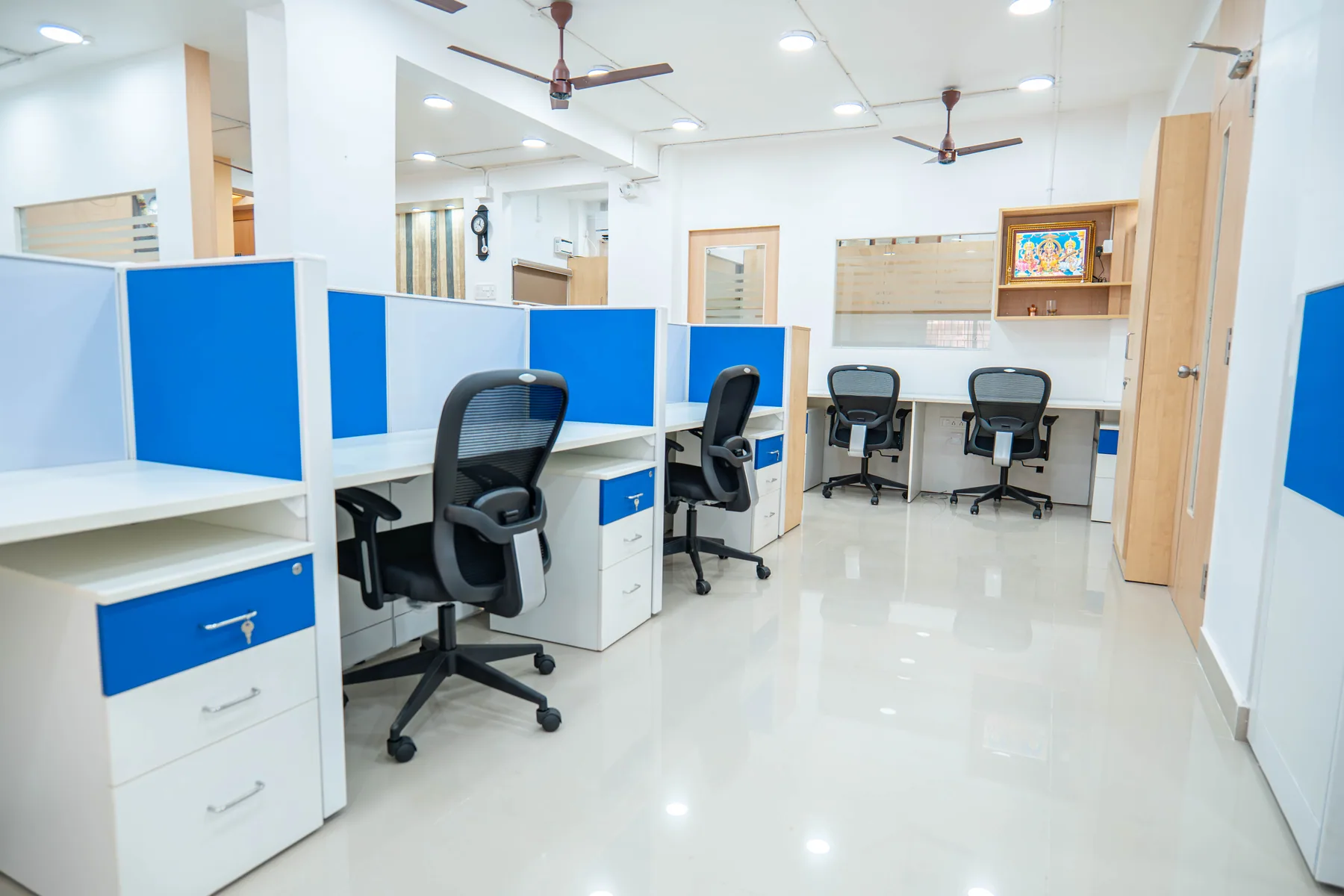 Open workstations with blue screens and wall-mounted storage