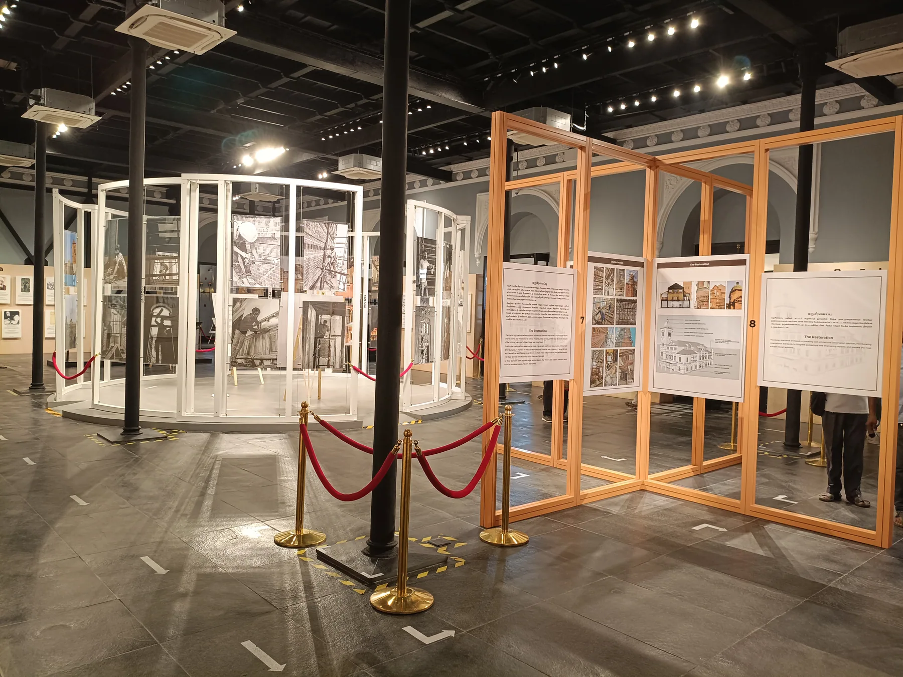 White and timber display structures across the gallery floor