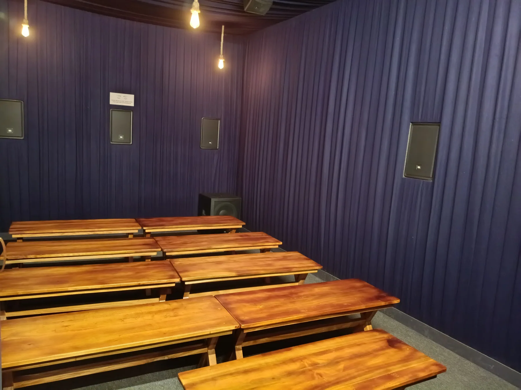 Timber benches inside a curtained screening room