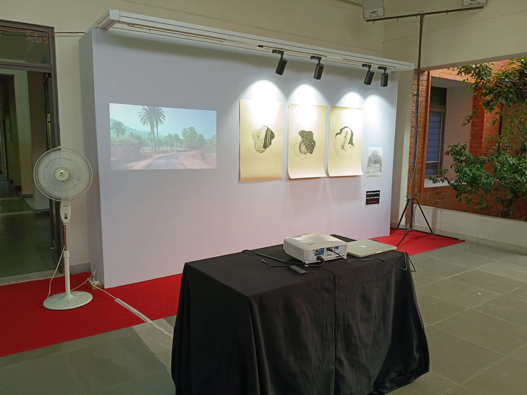 Spotlit artwork above a black display table