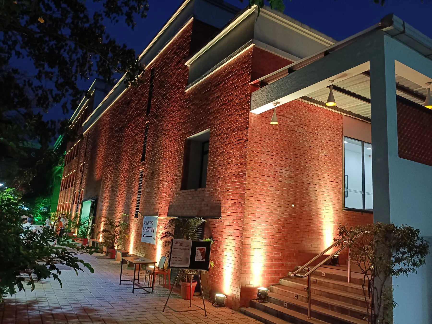 Warm uplighting on a red-brick exterior