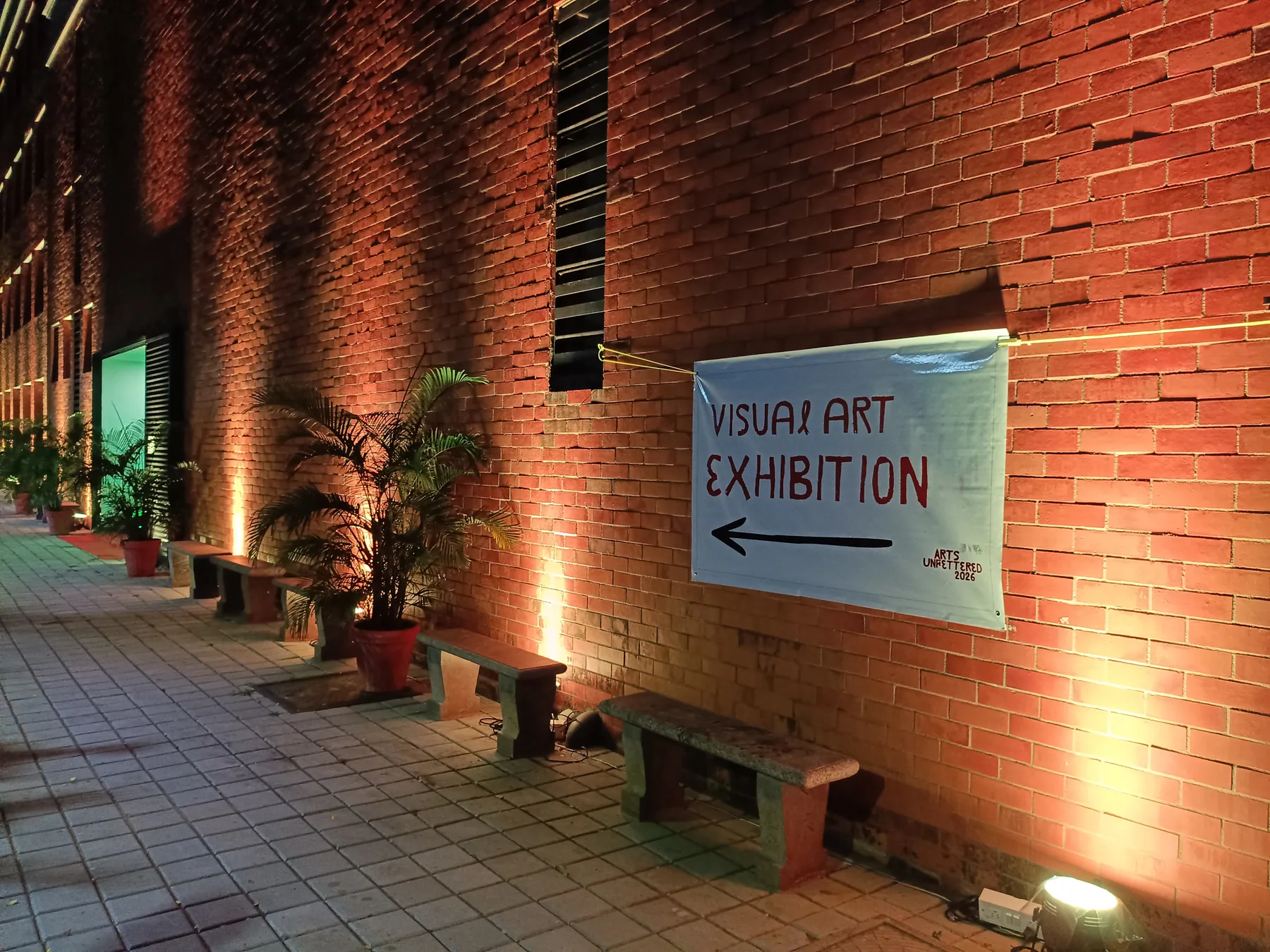 Exhibition direction sign beside the illuminated facade
